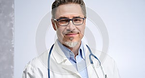 Portrait of happy smiling mid adult medical doctor on white