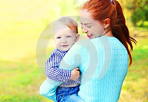 Portrait of happy smiling mother and son child outdoors in sunny park