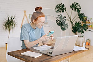 Portrait of happy smiling redhead young woman using phone.