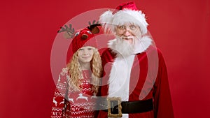 Portrait of Happy and Smiling Santa Claus in New Year's Costume and Blonde Teenage Girl Smiling and Hugging in Friendly