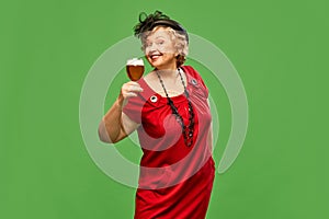 Portrait with happy, smiling senior lady, woman wearing red dress holding beer glasses with positive face over green