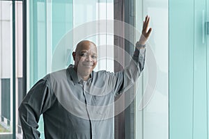 Portrait of happy smiling senior old elderly business Black African American man person standing, touching, and looking at the