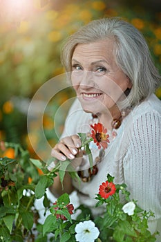 Portrait of a happy smiling senior woman with flowers