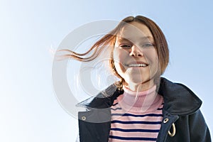 Portrait of happy smiling teenage girl in coat