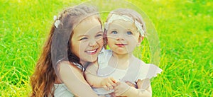 Portrait of happy smiling two little sister girls children together in summer park