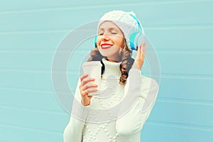 Portrait happy smiling woman with coffee cup enjoys listens to music