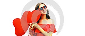 Portrait of happy smiling woman with red heart shaped balloon wearing sunglasses isolated on white background