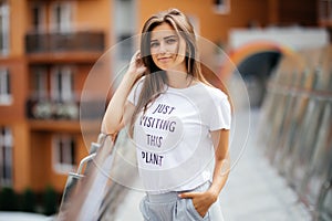 Portrait of happy smiling woman standing on the square on sunny summer or spring day outside, cute smiling woman looking at you, a