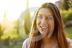Portrait of happy smiling woman standing on sunny summer or spring day outside. Cute smiling woman looking to the side filtered