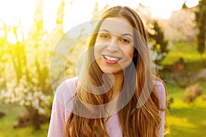 Portrait of happy smiling woman on sunny summer or spring day outside, cute smiling woman looking at you, attractive young girl