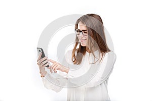 Portrait happy, smiling woman texting on her smart phone, isolated white background. Communication concept. Internet, phone addict