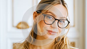 Portrait of happy smiling young attractive caucasian woman in eyeglasses looking on camera