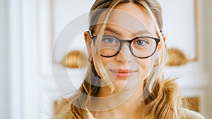 Portrait of happy smiling young attractive caucasian woman in eyeglasses looking on camera