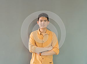 Portrait of happy smiling young business Asian, Chinese man person standing isolated in fashion design concept on gray background