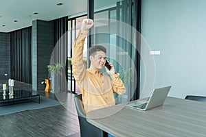 Portrait of happy smiling young business Asian, Chinese man person using laptop computer, working, and talking on smart mobile