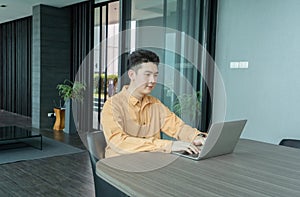 Portrait of happy smiling young business Asian, Chinese man person using laptop notebook computer, working online in meeting room