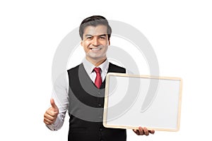 Portrait of happy smiling young businessman showing blank signboard with copyspace for text isolated on white background