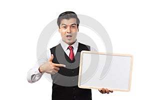 Portrait of happy smiling young businessman showing blank signboard with copy space for text isolated on white background