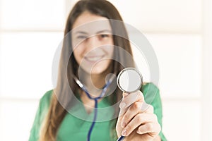Portrait of happy smiling young female doctor listening