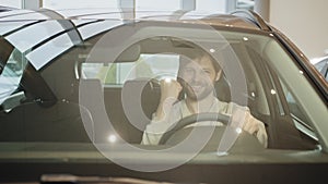 Portrait happy smiling young man buyer sitting in his new car excited ready for trip isolated outside dealer dealership