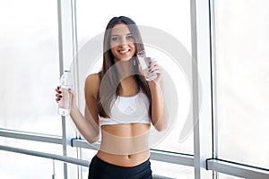 Portrait Of Happy Smiling Young Woman With Bottle Of Fresh Water