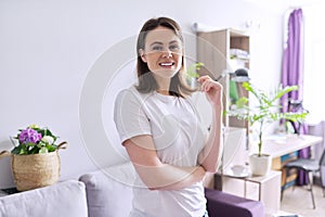 Portrait of happy smiling young woman looking at the camera in home