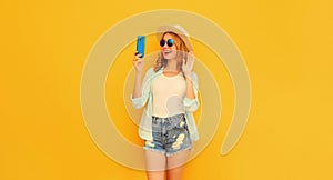 Portrait of happy smiling young woman taking selfie with smartphone or talking on video call waving hand wearing summer straw hat