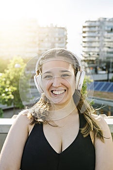 Portrait of happy sportive curvy woman with headphones after workout sesion