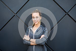 Portrait of Happy sports young lady standing and posing over black wall.