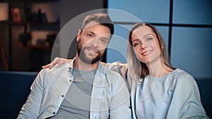 Portrait of happy spouses resting together in home in weekend night, smiling woman and man in room