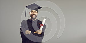 Portrait of a happy student in an academic dress and hat having a university or academy certificate.