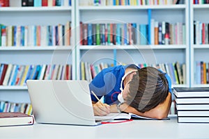 Portrait of happy student while reading book in school library.