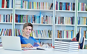 Portrait of happy student while reading book in school library.