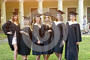 Portrait of happy students in graduation gowns