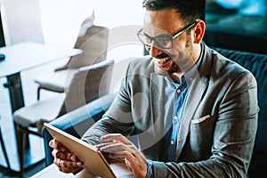 Portrait of happy succeffsul young business man, leader, ceo, manager using digital tablet to work.