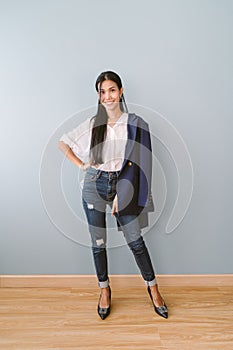 Portrait of happy successful confident Asian business woman in white shirts smiling at camera standing with hands on waist