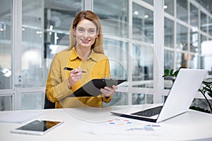 Portrait of happy successful woman financier doing paperwork, businesswoman holding papers, documents, contracts and