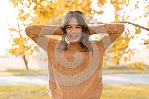 Portrait of happy surprised amazed young woman standing in park in autumn