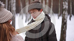 Portrait of happy teen boy with girl putting on scarf leaving with boyfriend. loving teenage Caucasian couple dating on