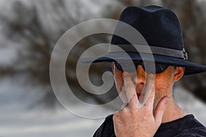 Teenage boy wearing black fedora hat