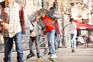 Happy teen skateboarding with friends at side walk