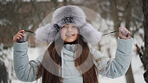 Portrait of a happy teenage girl in winter warm clothes and a fur hat