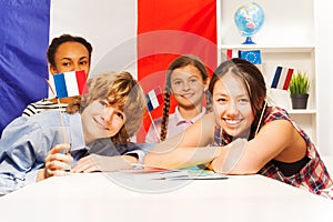 Portrait of happy teenage students holding flags