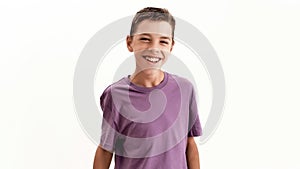 Portrait of happy teenaged disabled boy with cerebral palsy laughing at camera while posing, standing isolated over