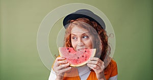 Portrait of happy teenager eating watermelon and smiling on green background