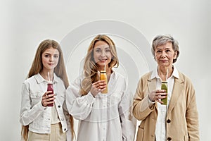 Portrait of happy three generations of women drink smoothies