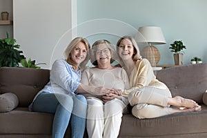 Portrait happy three generations women pose for family picture