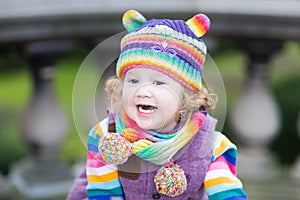 Portrait of a happy toddler girl in colorful knitted hat