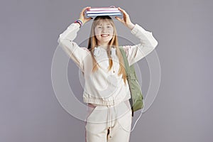 Portrait of happy trendy school girl in beige tracksuit