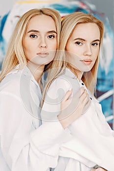 Portrait of happy twin girls artists. Sister girls in a photo studio on the sand.